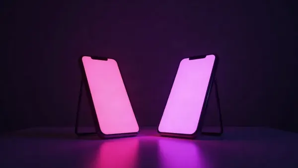 Zwei Smartphones einander gegenüber auf einem dunklen Tisch, eines rosa, das andere violett (Illustration zum Artikel)